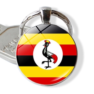 Detail showing round metal keychain with Uganda flag glass cabochon next to a key