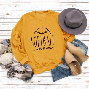 Flat lay du sweat jaune Softball Mom avec accessoires de saison sur fond de bois