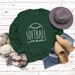 Mise à plat d'un sweat Softball Mom vert avec des accessoires de mode sur bois