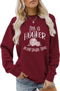 Close-up of the burgundy sweatshirt featuring a white crochet hook and yarn print design