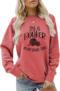Close-up of I'M a HOOKER in My Spare Time slogan with knitting graphic on pink sweatshirt