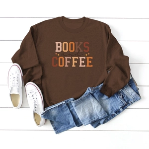 Flat lay of brown Books and Coffee sweatshirt styled with jeans on white wood background