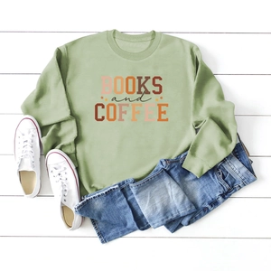 Detail of Books and Coffee sage green sweatshirt laid flat with denim and white sneakers