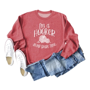 Detail of red crewneck sweatshirt featuring I'm a Hooker hobby slogan and yarn graphics