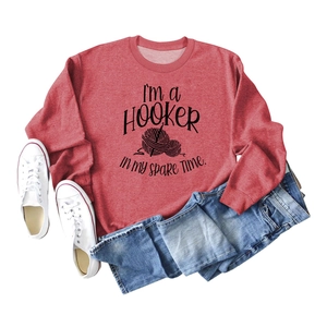 Detail of red crewneck sweatshirt featuring I'M a Hooker in My Spare Time crochet design