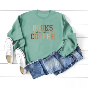 Flat lay of mint green sweatshirt with Books and Coffee print on white wood background