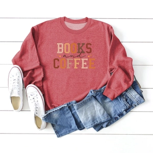 Close-up of Books and Coffee print on a brick red sweatshirt styled with blue jeans