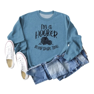 Flat lay of blue cotton sweatshirt with humorous text and illustration and sneakers