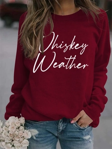 Close-up of Whiskey Weather white graphic print on a wine red long sleeve sweatshirt