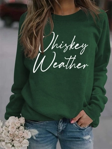 Close-up of Whiskey Weather letter print on dark green long sleeve sweatshirt fabric