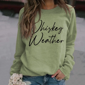 Detailed close-up of Whiskey Weather letter print on green long sleeve sweatshirt
