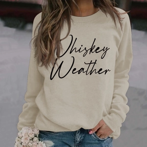 Detail showing Whiskey Weather letter print on a beige long sleeve sweatshirt for women