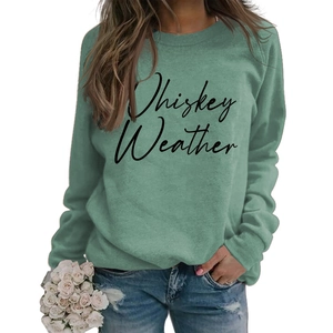 Detail of Whiskey Weather script print on a Morandi green crewneck sweatshirt fabric