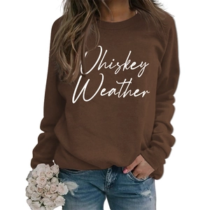 Detailed view of Whiskey Weather printed text on dark brown crewneck sweatshirt