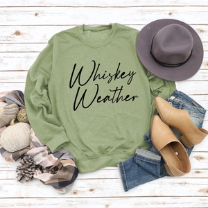 Flat lay of Whiskey Weather green sweatshirt with autumn boots and accessories