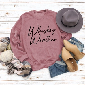 Flat lay of Whiskey Weather sweatshirt with autumn accessories on white wood