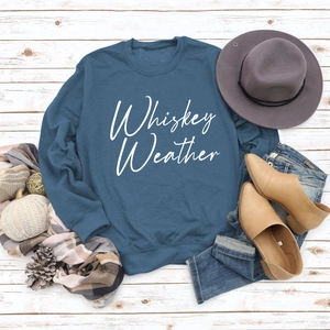 Navy sweatshirt with Whiskey Weather print styled with autumn accessories on wood background