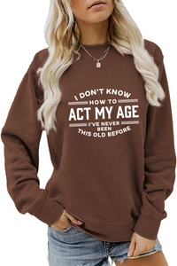 Dettaglio felpa marrone girocollo con stampa bianca I Don't Know How To Act My Age sul petto
