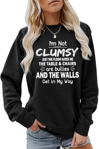 Detail of the white slogan print on a black crewneck sweatshirt with ribbed cuffs