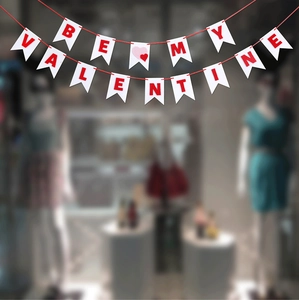 Detail of Be My Valentine felt banner with red letters and hearts for proposal decor
