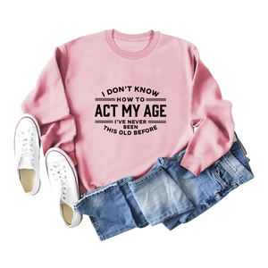 Felpa rosa con scritte nere in piano con scarpe da ginnastica bianche e jeans denim