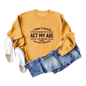 Piatto di felpa giallo senape con scritta abbinata a jeans e sneakers bianche casual