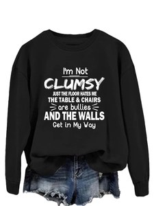 Close-up of black crew neck sweatshirt featuring humorous white text print and ribbed cuffs