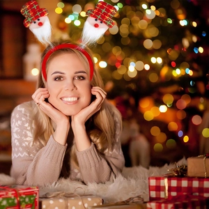 Close-up of Santa Claus headband with spring details and red plaid hat on a model