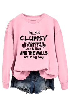 Detail of pink crewneck sweatshirt with humorous black text print and cotton fabric texture