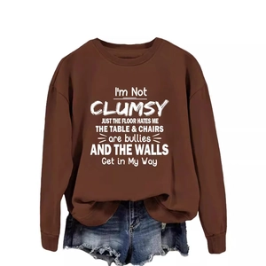 Brown crewneck sweatshirt with 'I'M NOT CLUMSY' slogan paired with denim shorts