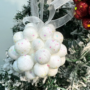 Glittering white foam Christmas ball ornaments with sequins on a snowy pine tree branch