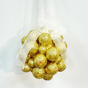 Close-up of golden glitter foam balls cluster with white organza bow for Christmas tree decor