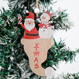 Christmas wooden Santa and Snowman hanging ornament with red Xmas text on a tree
