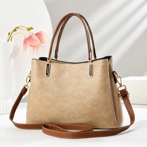 Detail of vintage embossed leather texture on beige handbag with gold metal hooks
