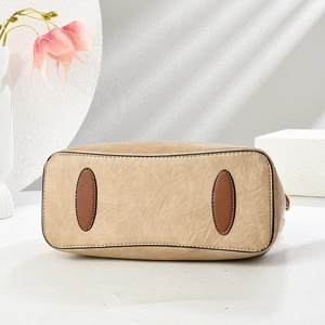 Macro detail of the reinforced khaki leather bag base with brown anti-wear patches