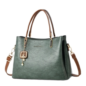 Retro dark green leather shoulder bag with brown handles and a gold fashion logo