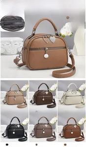 Detail view of mini crossbody bag showing multiple zipper compartments and dimensions