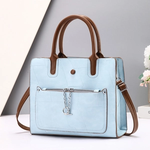 Light blue tote bag with geometric texture, brown handles and metal chain detail