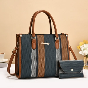 Detail of a two-piece woven tote bag set with brown leather straps and metal logo