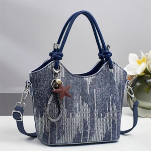 Blaue Denim-Beuteltasche mit geometrischen Linien und Stern-Anhänger für Damen im Studio
