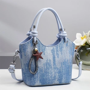 Detailansicht der hellblauen Bucket-Bag in Denim-Optik mit Knotengriff und Sternanhänger