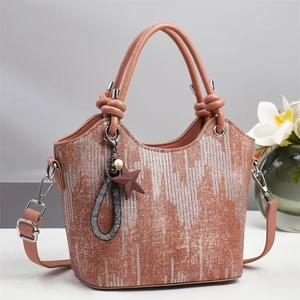 Detail der rosabraunen Beuteltasche mit geometrischer Textur, Sternanhänger und Silber-Hardware