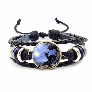 Macro detail of Halloween woven leather bracelet featuring a black cat glass gemstone