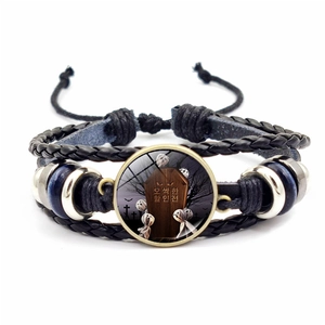 Detail of multi-layer woven leather bracelet with Halloween glass cabochon and ghost motif