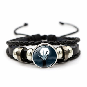 Dettaglio macro del bracciale intrecciato multistrato con charm cupola di vetro zombie