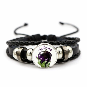 Detail of Halloween woven leather bracelet featuring a purple apple glass cabochon