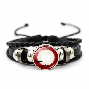 Macro view of multilayer leather bracelet featuring a bat glass gem and silver beads
