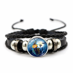 Macro detail of Halloween leather bracelet showing pumpkin glass pendant and silver beads