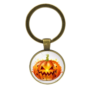Detail of Halloween pumpkin glass gem keychain with vintage bronze metal ring and orange finish