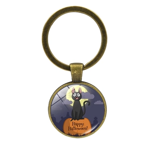 Macro view of vintage bronze Halloween keychain with black cat and pumpkin glass gem